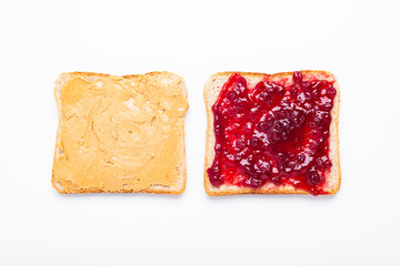 Peanut butter and jelly sandwich halves on a white background, top view