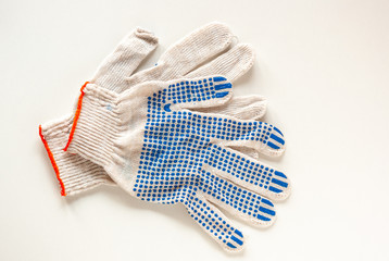 Cream-colored construction gloves with blue specks on a white background