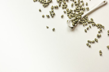 Tea ginseng oolong dispersed on a white plate with a white ceramic spoon. Copyspace.