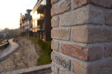 Fototapeta na wymiar Old brick wall and modern architecture buildings in the background during sunset