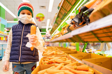 little girl in medical mask, gloves buys carrot