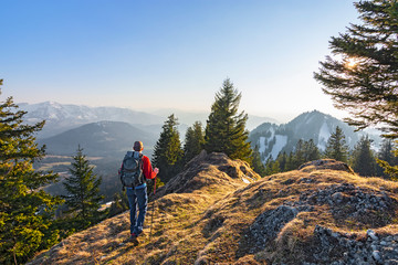 Man with backpack hiking in the mountains at sunset. Allgau Alps, Bavaria, Germany