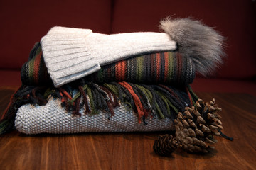 Close-up of jersey, hat and scarf on table, orange and grey, sofa in background