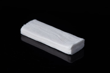 White medical cotton gauze bandage on white, black background, Medical bandage of new first aid gauze unrolling