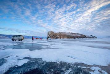 Touristengruppe mit UAZ Bus auf dem gefrorenen Baikalsee vor der Felsinsel Ogoi
