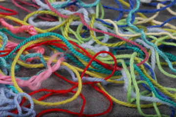 Tangled colorful needlecraft threads. Knitting yarn close-up. Knitting is needlework and creativity. Abstract colors background, copy space.