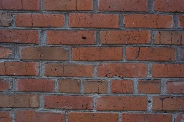 Brick masonry of bright red color in the form of a wall
