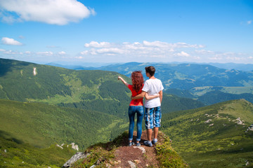 Happy couple hugging in the top of mountain.
