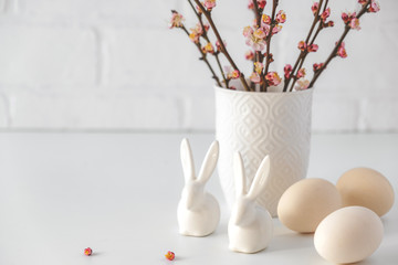 Easter composition with flowering pink cherry branch in vase on white background. Easter holiday spring concept .Traditional decor. Greeting card.