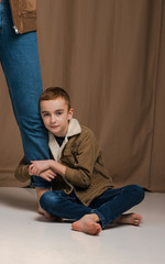 close-up portrait siblings with brown eyes in studio with brown nude texture background have a fun,laghfing, smiling, love each other in brown jackets