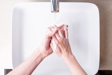Washing hands with soap in the bathroom