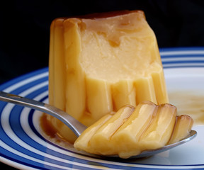 Flan dessert with sweett caramel sauce over black background. Caramel custard pudding over a dish