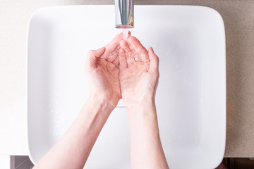 Washing hands with soap in the bathroom