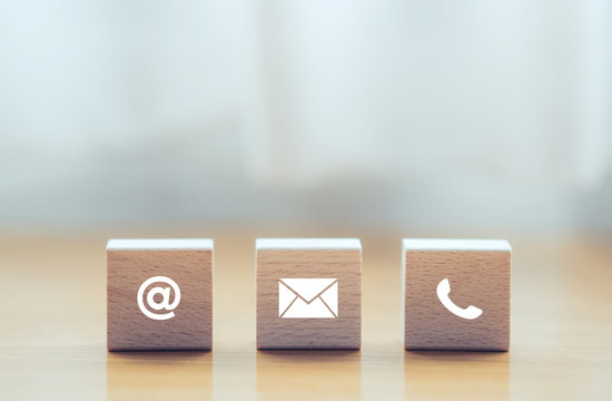 contact us icon (phone, email, mail ) on wood cube, customer service and support for self quarantine business working at home for Coronavirus or virus preventing concept