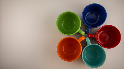 multicolored mugs on a white background