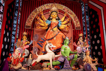 Fototapeta premium Idol of Goddess Devi Durga at a decorated puja pandal in Kolkata, West Bengal, India. Durga Puja is a popular and major religious festival of Hinduism that is celebrated throughout the world.