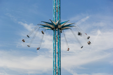 Carousel on the background of a blue sky with clouds