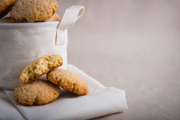 homemade biscuits in a linen basket on a beige background. cracked cookies. Healthy sweets cooking for family.