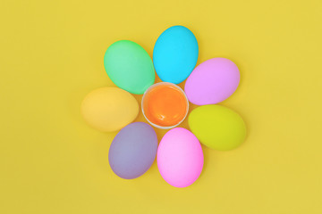 Close up - Different Colored Chicken Eggs a circle as a flower in the middle of the yolk on a yellow background