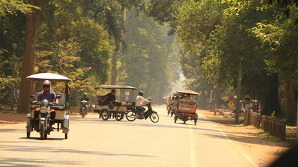 Tuk tuts driving down road in Cambodia