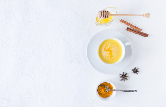 Top view image of turmeric latte over white table with copy space