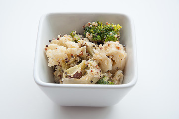 Vegan casserole food with broccoli, cauliflower, beans and quinoa served in a square bowl on a light background.  Great for healthy lifestyles and whole plant diets with this vegetable side dish.