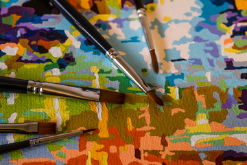 Art brushes and painting. Brush strokes of bright colors close-up. A fragment of the picture. Macro photo. Painter