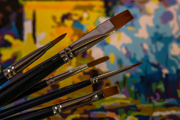 Art brushes and painting. Brush strokes of bright colors close-up. A fragment of the picture. Macro photo. Painter