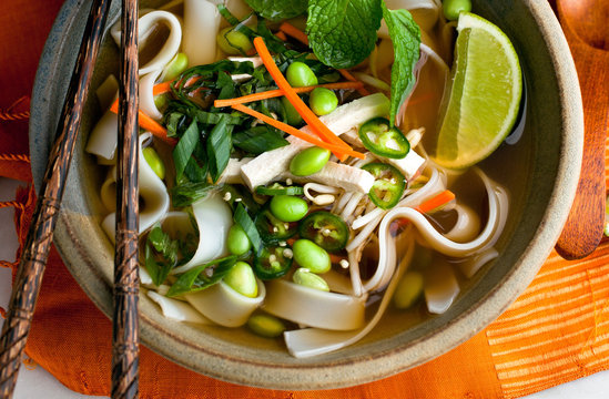 Vegan pho with carrots, noodles and edamame