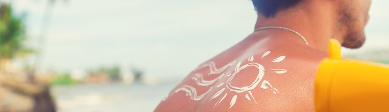 A Man On The Beach With Sunscreen On His Back. Selective Focus.