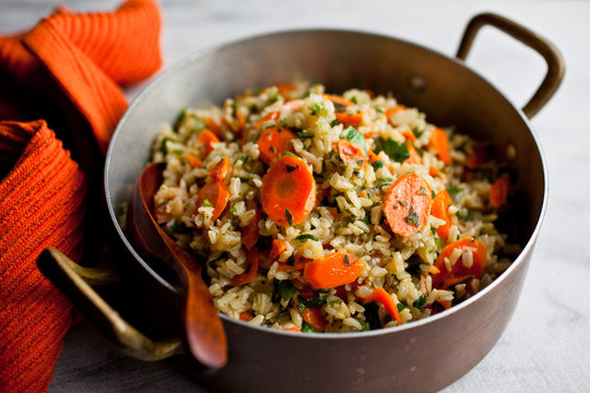 Fried rice with carrots and parsley in saucepan
