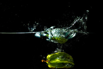 fresh starfruit water splash with black background