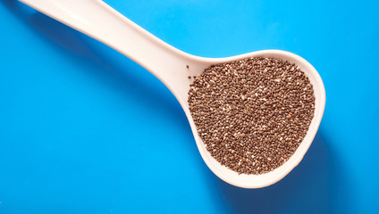 chia seeds in a spoon on a blue background