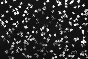 Silver stars on black background. holiday concept. creative layout.