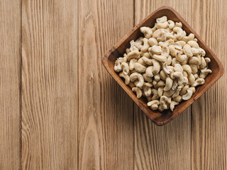  cashew nuts in a bowl on a wooden background. Rustic style. Vegetarian food.