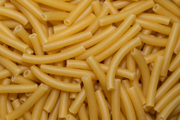 Uncooked smooth short tubes shape pasta also known as tubetti lisci background and texture