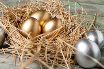 Eggs in a nest. Easter golden and silver eggs