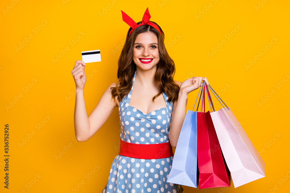 Sticker Portrait of positive cheerful shopping center client girl buy many bags pay with credit card hold wear blue vintage clothes red headband isolated over bright shine color background