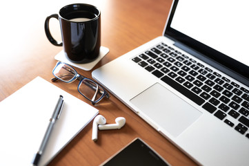 Businesswoman's home office desk with coffee mug and laptop . Business and Technology Concept