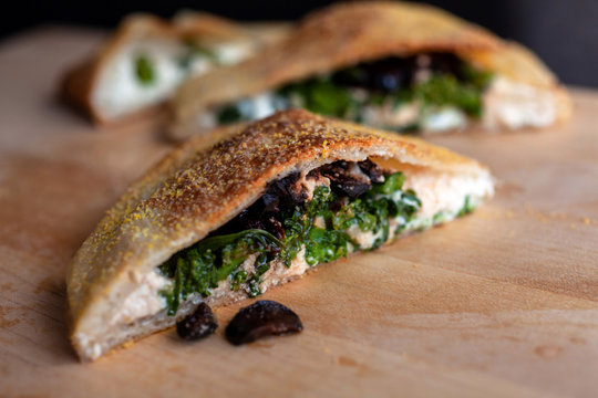 Cross section of broccoli rabe, olive and parmesan calzones
