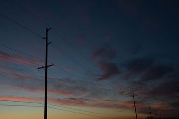 Power lines against sunset sky and clouds