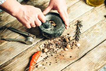 male hands crush spices in a mortar © Marina