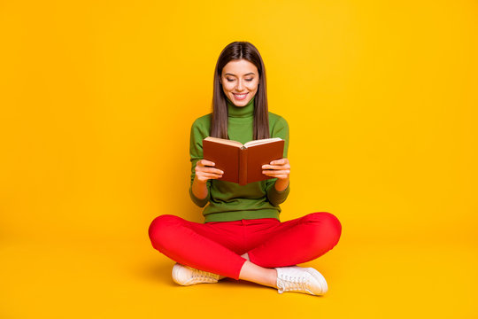 Photo of funny pretty beautiful lady sit floor holding school literature book reading most exciting cool moment wear casual green jumper red trousers isolated yellow color background