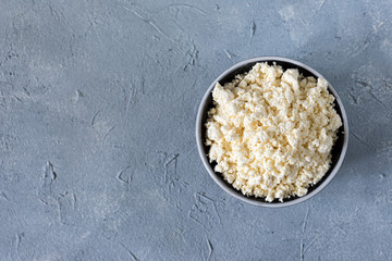 tasty useful fresh cottage cheese, cottage cheese. Homemade white cheese crumbles in a porcelain bowl