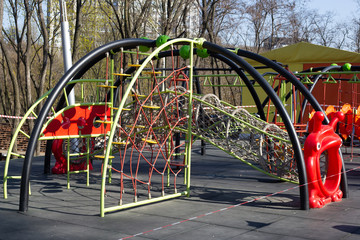 Red caution tape on kids playground, closed due to COVID-19 quarantine