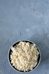 tasty useful fresh cottage cheese, cottage cheese. Homemade white cheese crumbles in a porcelain bowl
