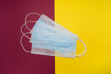 Disposable medical masks on a colored background. Quarantine. Self-isolation.