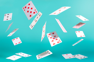flying playing cards on a turquoise background - obrazy, fototapety, plakaty