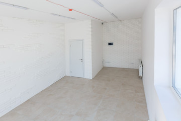 Office extension that uses bricks as a wall, construction, improvement. Interior of small room with window and bricks walls renovation, extension, overhaul and reconstruction.