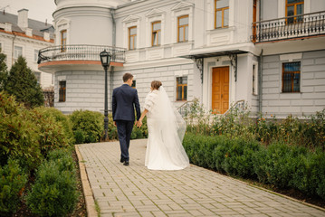 Happy bride and groom on their wedding. Bride and groom at wedding day walking outdoors. Happy couple. Wedding photo. Couple in love.